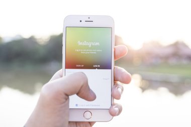 CHIANG MAI, THAILAND - JANUARY 02, 2015: A man trying to log in Instagram application using Apple iPhone 6. Instagram is largest and most popular photograph social networking site in the world.