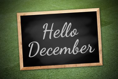 Hello December on chalk board and green field background and texture