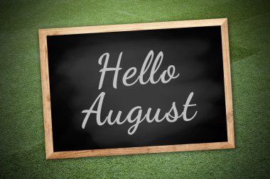 Hello August on chalk board and green field background and texture