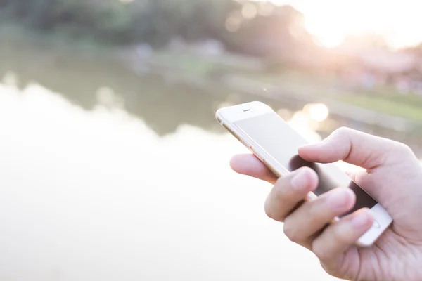 Adam el smartphone karşı yumuşak arka planda tutarak. — Stok fotoğraf