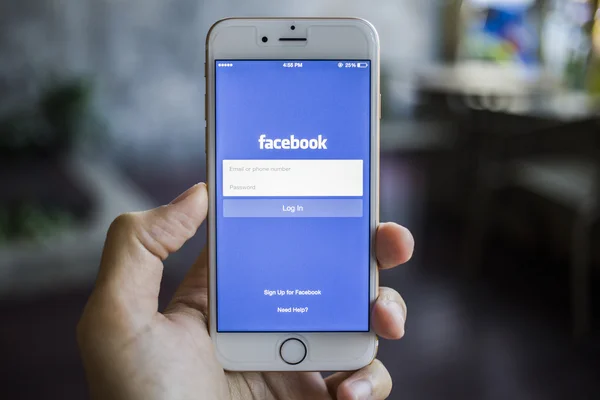 CHIANG MAI, THAILAND - JANUARY 02, 2015: A man trying to log in Facebook application using Apple iPhone 6. Facebook is largest and most popular social networking site in the world. — Stock Photo, Image