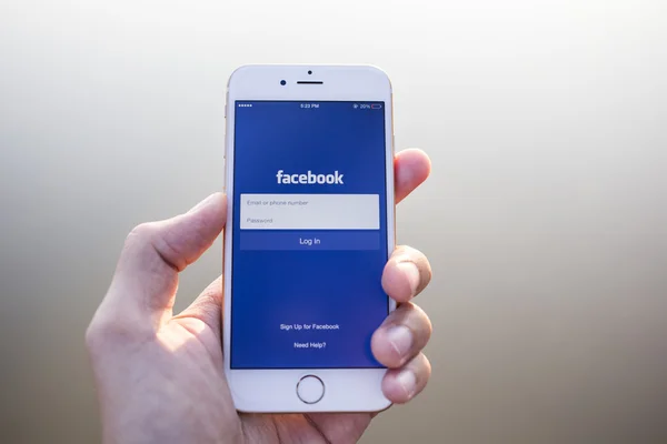 CHIANG MAI, THAÏLANDE - 02 JANVIER 2015 : Un homme tente de se connecter à l'application Facebook en utilisant Apple iPhone 6. Facebook est le site de réseautage social le plus grand et le plus populaire au monde . — Photo