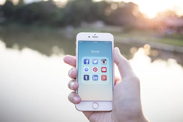 CHIANG MAI, THAILAND - JANUARY 02, 2015: All of popular social media icons on smartphone device screen with hand holding on Apple iPhone 6. — Stockfoto