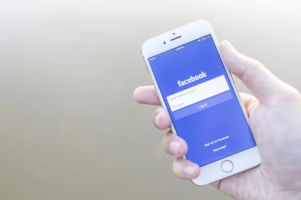 CHIANG MAI, THAILAND - JANEIRO 02, 2015: Um homem tentando fazer login no aplicativo do Facebook usando o Apple iPhone 6. Facebook é o maior e mais popular site de redes sociais do mundo . — Fotografia de Stock