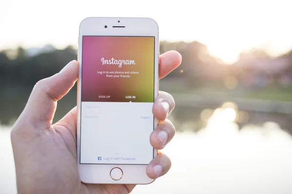 CHIANG MAI, THAILAND - JANUARY 02, 2015: A man trying to log in Instagram application using Apple iPhone 6. Instagram is largest and most popular photograph social networking site in the world. — Stockfoto