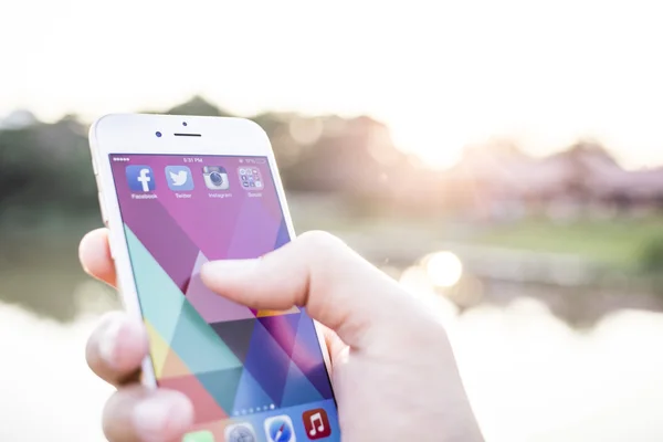 CHIANG MAI, THAILAND - JANUARY 02, 2015: All of popular social media icons on smartphone device screen with hand holding on Apple iPhone 6. — Stockfoto