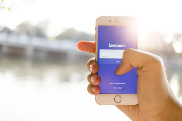CHIANG MAI, THAILAND - ЯНВАРЬ 04, 2015: Человек пытается войти в Facebook приложение с помощью Apple iPhone 6. Facebook является крупнейшей и самой популярной социальной сетью в мире . — стоковое фото