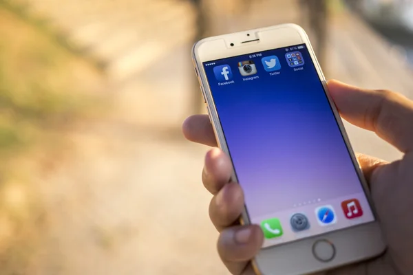 CHIANG MAI, THAILAND - JANUARY 04, 2015: All of popular social media icons on smartphone device screen with hand holding on Apple iPhone 6. — Stockfoto