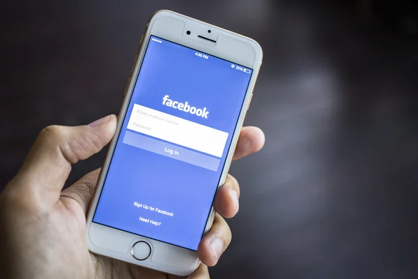 CHIANG MAI, THAILAND - JANUARY 02, 2015: A man trying to log in Facebook application using Apple iPhone 6. Facebook is largest and most popular social networking site in the world. — Stockfoto