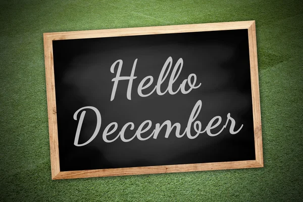 Hello December on chalk board and green field background and texture — Stockfoto