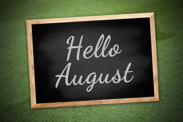 Hello August on chalk board and green field background and texture