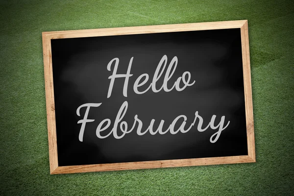 Hello February on chalk board and green field background and tex — Stockfoto