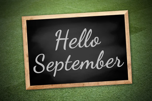 Hello Septemberconcept on chalk board and green field background — Stock Photo, Image