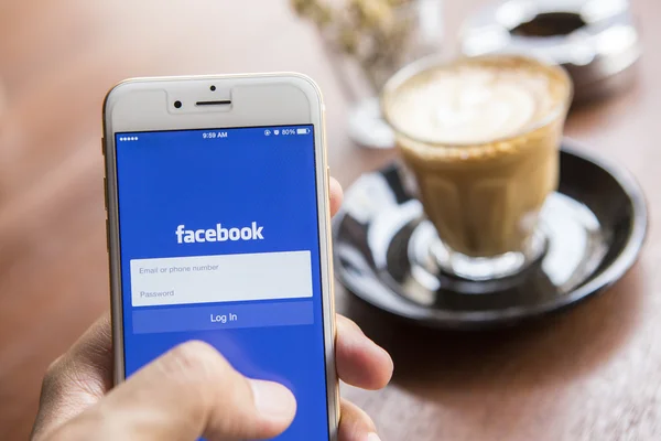 CHIANG MAI, THAILAND - APRIL 22, 2015: A man trying to log in Facebook application using Apple iPhone 6. Facebook is largest and most popular social networking site in the world. — Stockfoto