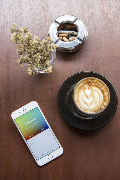 CHIANG MAI, THAILAND - APRIL 22, 2015: Instagram application using Apple iPhone 6 on coffee shop table. Instagram is largest and most popular photograph social networking site in the world. — Stock Photo, Image