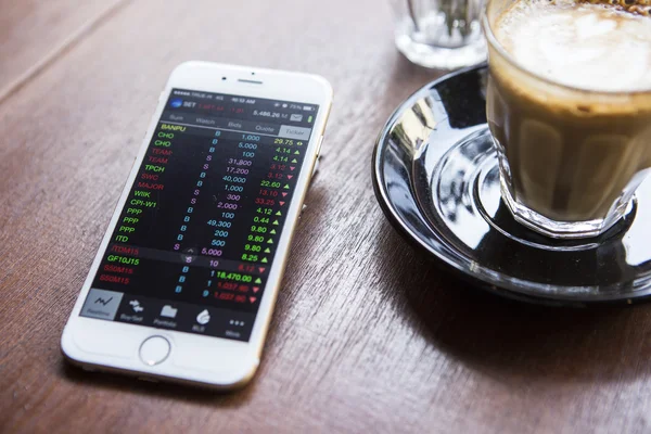 CHIANG MAI, THAILAND - APRIL 22, 2015: iPhone 6 with application Stocks of Apple on the screen in coffee shop cafe. iPhone 6 was created and developed by the Apple inc. — Stockfoto