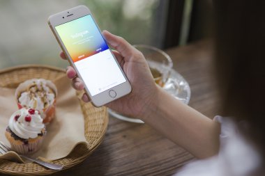 CHIANG MAI, THAILAND - JUNE 28, 2015: Woman trying to log in Instagram application using Apple iPhone 6. Instagram is largest and most popular photograph social networking site in the world.