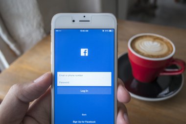 Chiang Mai, Tayland - 23 Temmuz 2015: Apple iphone 6 kullanarak Facebook uygulamada oturum çalışan adam. Dünyanın en büyük ve en popüler sosyal ağ sitesi Facebook olduğunu.