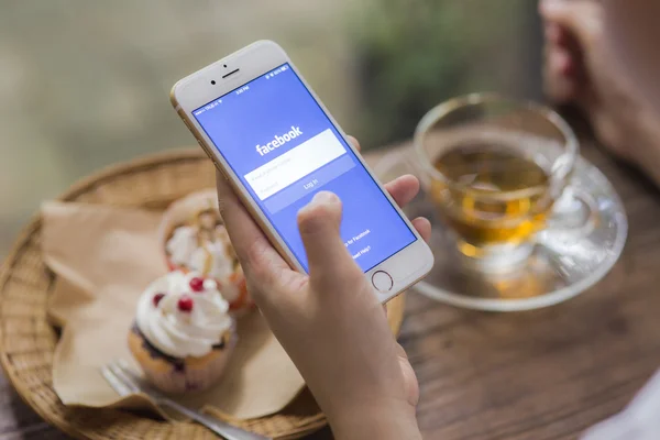 CHIANG MAI, THAILAND - JUNE 28, 2015: Woman trying to log in Facebook application using Apple iPhone 6. Facebook is largest and most popular social networking site in the world. — Stock Photo, Image