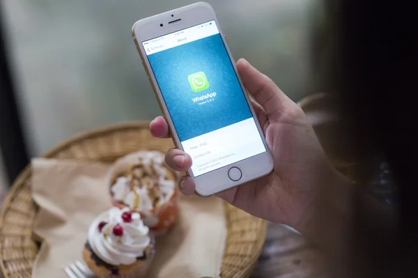 CHIANG MAI, THAILAND - JUNE 28, 2015: Woman hold iPhone 6 with social Internet service WhatsApp on the screen in coffee shop. iPhone 6 was created and developed by the Apple inc. — Stockfoto