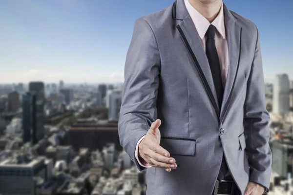 Business man handshake on business building background — Stok fotoğraf