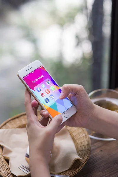 CHIANG MAI, THAILAND - JUNE 28, 2015: All of popular social media icons on smartphone device screen Apple iPhone 6 on woman hand in coffee shop cafe. — 图库照片