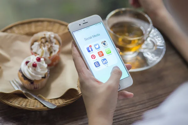 CHIANG MAI, THAILAND - JUNE 28, 2015: All of popular social media icons on smartphone device screen Apple iPhone 6 on woman hand in coffee shop cafe. — Zdjęcie stockowe