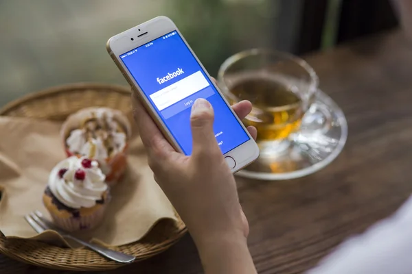 Chiang Mai, Tajlandia - 28 czerwca 2015: Kobieta próbuje się zalogować w Facebook aplikacji za pomocą Apple iphone 6. Facebook jest największym i najbardziej popularny portal społecznościowy na świecie. — Zdjęcie stockowe