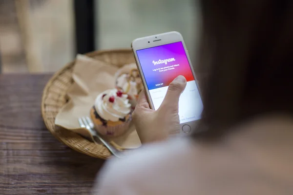 CHIANG MAI, THAILAND - JUNE 28, 2015: Woman trying to log in Instagram application using Apple iPhone 6. Instagram is largest and most popular photograph social networking site in the world. — Stok fotoğraf