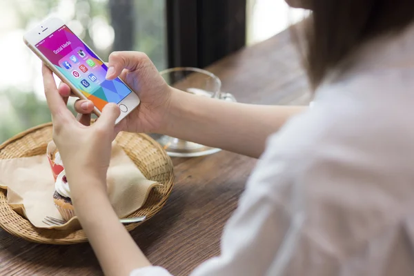 CHIANG MAI, THAILAND - JUNE 28, 2015: All of popular social media icons on smartphone device screen Apple iPhone 6 on woman hand in coffee shop cafe. — 图库照片