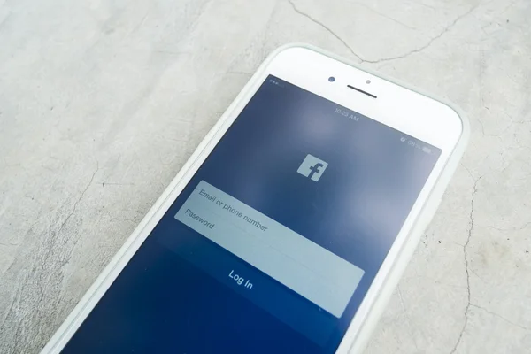 CHIANG MAI, THAILAND - 23 июля 2015 года: Man trying to log in Facebook application using Apple iPhone 6. Facebook является крупнейшей и самой популярной социальной сетью в мире . — стоковое фото