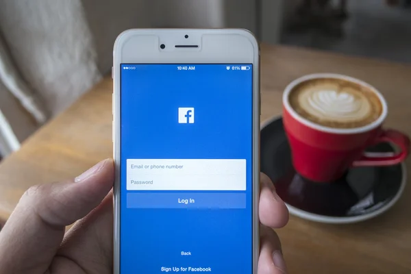 Chiang Mai, Tajlandia - 23 lipca 2015: Człowiek stara się Zaloguj się Facebook aplikacji za pomocą Apple iphone 6. Facebook jest największym i najbardziej popularny portal społecznościowy na świecie. — Zdjęcie stockowe