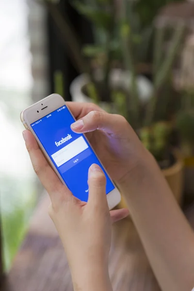 Chiang Mai, Thailand - 28 juni 2015: Vrouw probeert in te loggen in Facebook applicatie met behulp van Apple iphone 6. Facebook is de grootste en meest populaire sociale netwerksite ter wereld. — Stockfoto