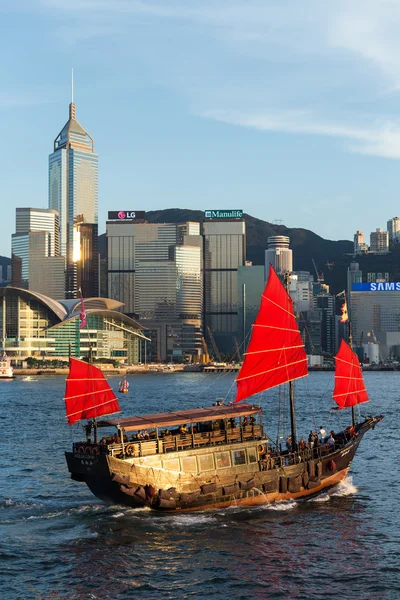 Hong Kong victoria habour with red ship and building in background.