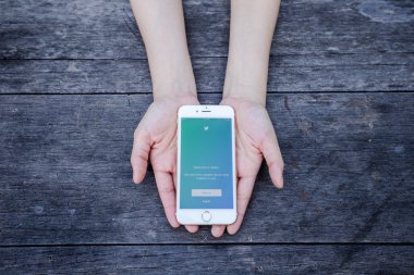 Chiang Rai, Tayland - 13 Eylül 2015: Kadın Twitter Uygulama Apple iPhone için 6 mavi arka plan oturum açmanız deneyin. Dünyanın en büyük ve en popüler sosyal ağ sitesi Twitter olduğunu.