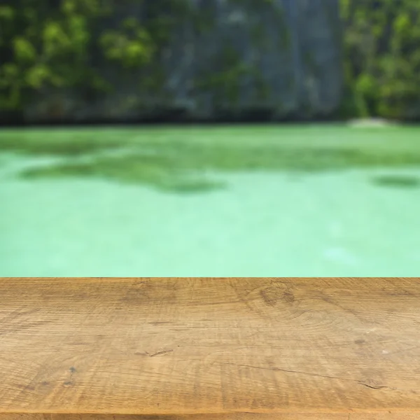 Tampo da mesa de madeira no fundo azul embaçado do mar usado para exibir seu produto — Fotografia de Stock