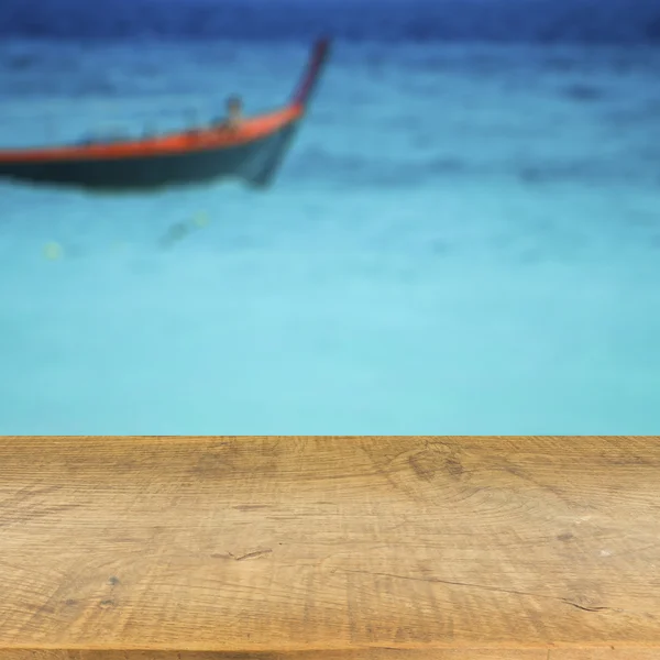 Piano in legno su sfondo blu mare sfocato utilizzato per visualizzare il prodotto — Foto Stock