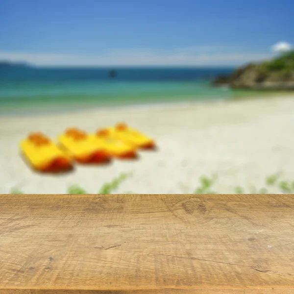 Piano in legno su sfondo blu mare sfocato utilizzato per visualizzare il prodotto — Foto Stock