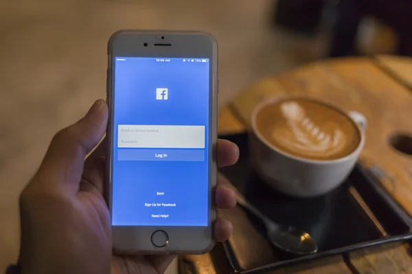 泰国清迈-2016 年 1 月 25 日: 一名男子企图在使用苹果 iphone 6s 的 Facebook 应用程序日志。Facebook 是规模最大、 最受欢迎的社交网站中的世界. — 图库照片