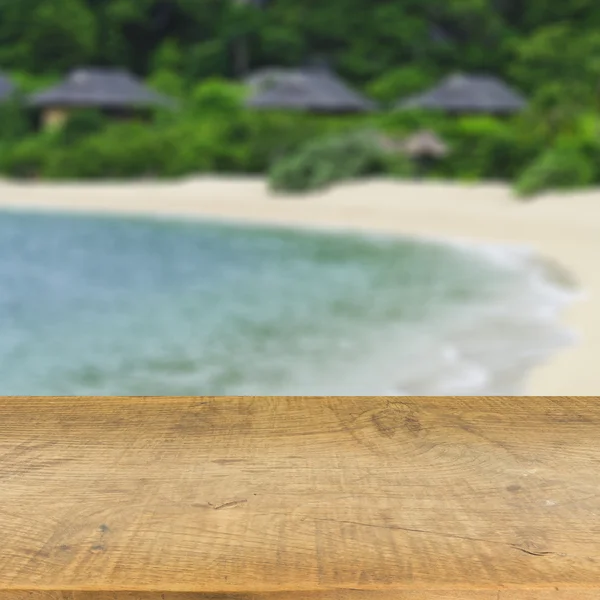 Τραπέζι από ξύλο πάνω σε φόντο θολή μπλε της θάλασσας που χρησιμοποιείται για επίδειξη y Εικόνα Αρχείου