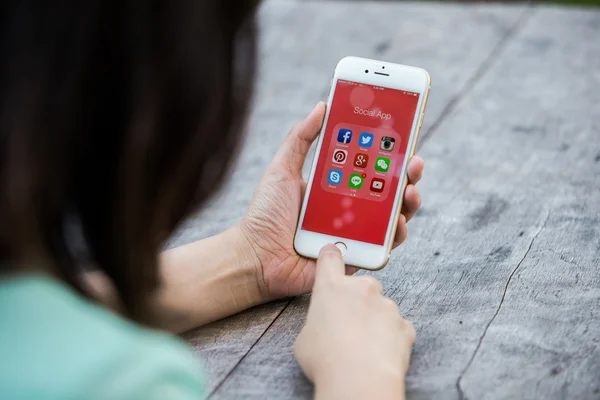 Chiang rai, Thailand - 13. September 2015: Frau mit Apple-iPhone zeigt alle populären Social-Media-Symbole auf dem Bildschirm des Smartphones. Stockbild