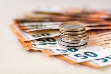 50 avroluk banknotların üzerindeki para yığını bej bir masanın üstündeki vantilatörde katlanmış. Zenginlik, nakit tasarrufu, gelir ve gider hesapları. Yüzeyin derinliği. Ön görünüm.