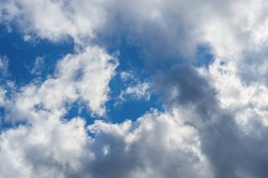 Parlak mavi gökyüzü beyaz-gri bulutlarda boşluklar gösteriyor. Meteoroloji, bulutlar ve rüzgar. Güneşli havadan bulutlu havaya geçiş. Hava tahmini. Gündüz.