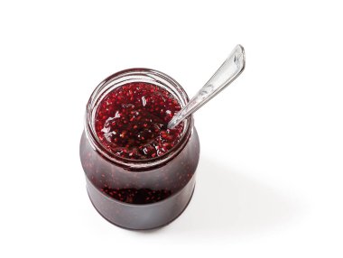 Beyaz arka planda izole edilmiş lezzetli ahududu reçeli dolu açık kavanozda bir kaşık. Geleneksel ev yapımı kırmızı böğürtlen reçeli, marmelat ya da tatlı hamur işleri ve sandviç malzemesi olarak konfeksiyon. Üst görünüm.