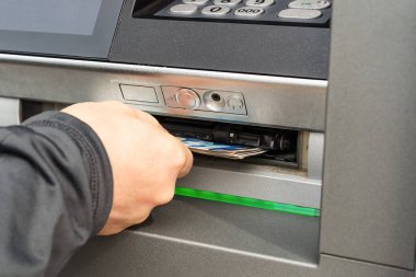 Kafkasyalı adam ATM 'den para alıyor. Bir gün açık hava nakit çekimi. Erkek eli üzerinden ATM 'den çekilen Bulgar Levası. Banka ATM 'si kullanılıyor. Seçici odaklanma. Yakın plan..