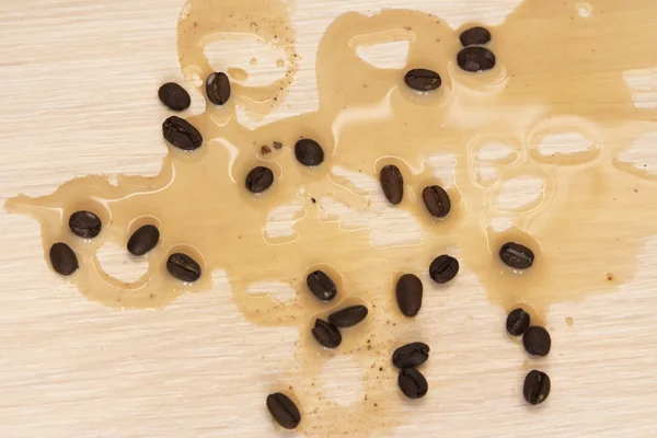 Ter plaatse van gemorste koffie op de tafel en de koffie bonen — Stockfoto