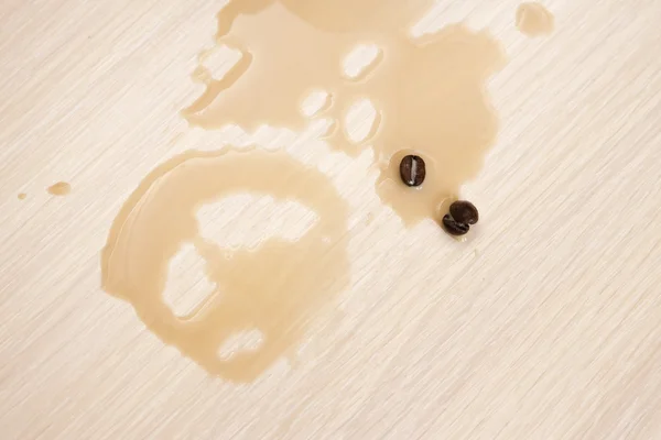 Ter plaatse van gemorste koffie op de tafel en de koffie bonen — Stockfoto