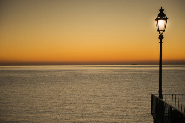 Farola iluminada durante la puesta del sol — Foto de Stock