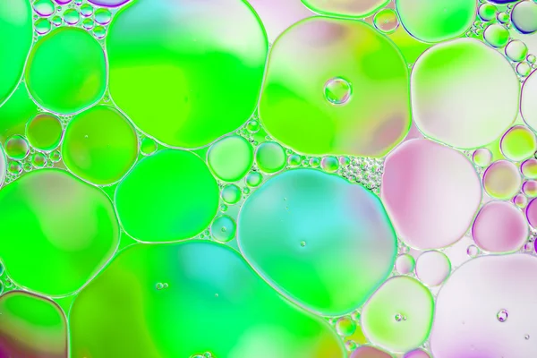 Oil drops in water on a coloured background — Stock Photo, Image