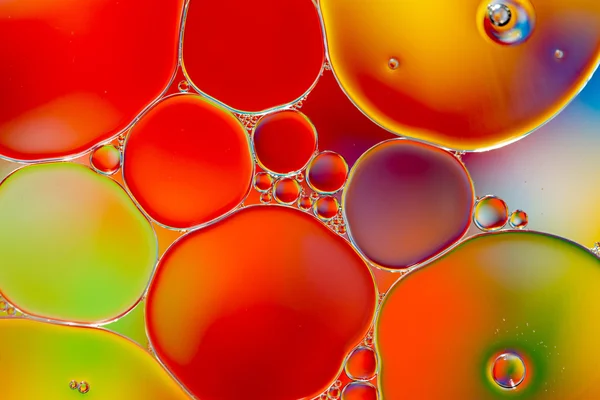 Oil drops in water on a coloured background